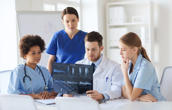 group of doctors discussing x-ray image