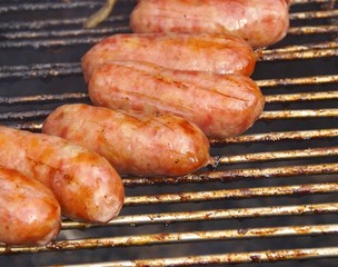 Barbecued meat and pork sausages on grill