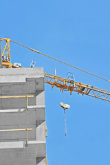 Crane and building construction site against blue sky