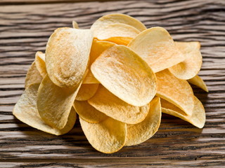 Potato chips on a wooden background.