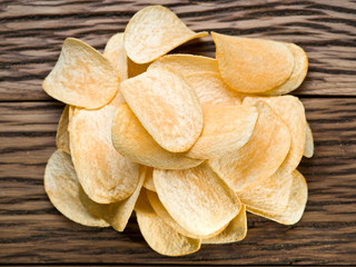 Potato chips on a wooden background.