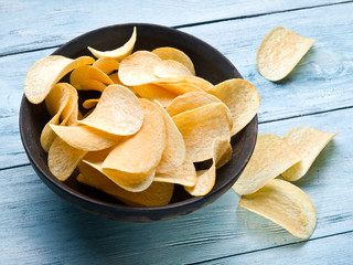Potato chips on a wooden background.