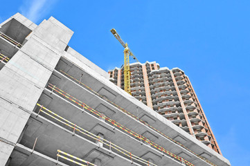 Crane and building construction site against blue sky