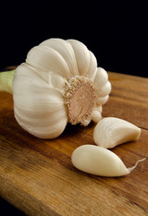 Two segments of garlic on a kitchen board.