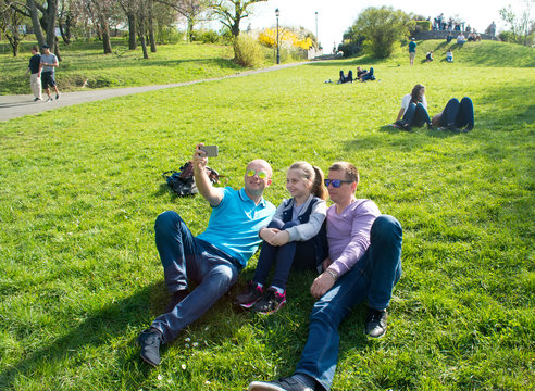 Group of smiling friends  taking selfie in the park