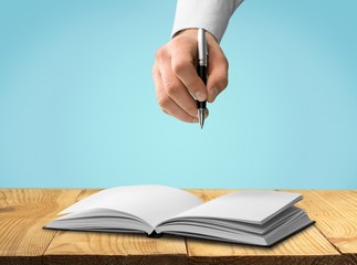 Sketching. Opened book and hand drawing building sketches