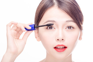 Asian female applying mascara