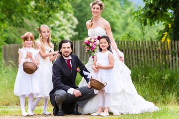 Hochzeitspaar bei Heirat mit Blumenkindern 