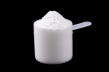 Scoop of whey protein isolated on black