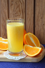 A glass of orange juice and orange slices.