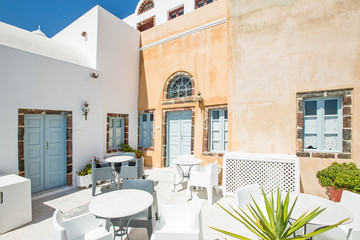 street cafe and white wall on Santorini in Greece