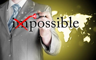 Businessman Hand turning the word Impossible into Possible with