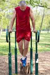 Obraz premium Senior Exercising In Sport Park