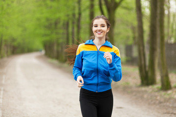 Young beautiful woman running on a trail