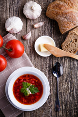 Borsch with bread on a wooden background.
