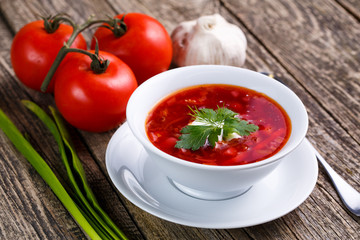 Borsch with bread on a wooden background.
