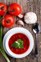 Borsch with bread on a wooden background.