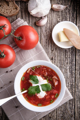Borsch with bread on a wooden background.