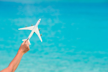 Fototapeta na wymiar Small white toy airplane on background of turquoise sea