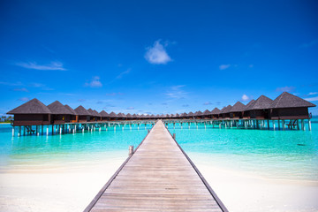 Fototapeta premium Water bungalows and wooden jetty on Maldives
