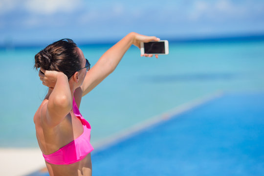 Young beautiful woman taking selfie with phone outdoors during