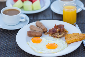 Delicious breakfast with fried eggs, bacon and sausages
