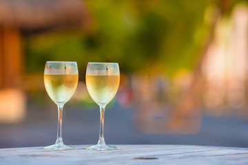 Two glasses of tasty white wine at sunset