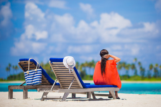 Beautiful young woman relaxing at beach loungers