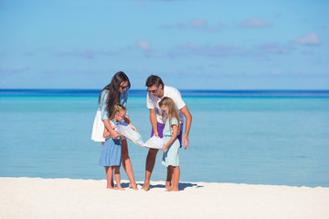 Happy family with map on the beach