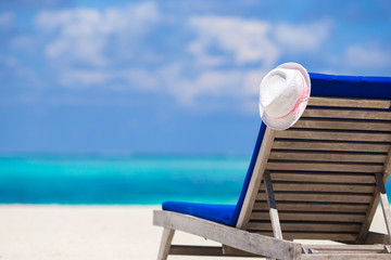 Lounge chairs with hat on tropical beach at Maldives