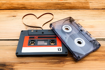 Vintage audio cassette with loose tape shaping two hearts on a w