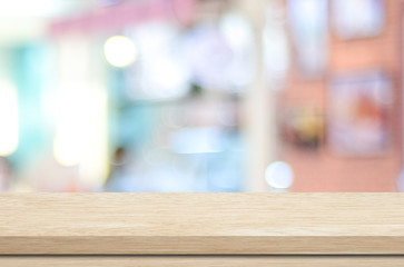 Empty wood table and blurred cafe with bokeh light background