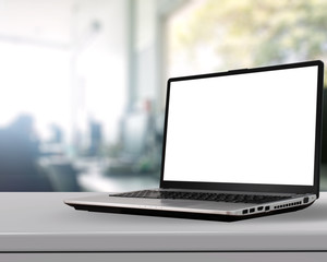 Laptop with blank screen on white desk with blurred background a