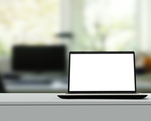 Laptop with blank screen on white desk with blurred background a