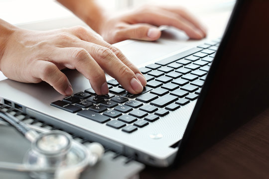 close up of Doctor hand using laptop computer in office