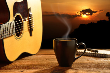 Cup of coffee and guitar with the sun in background