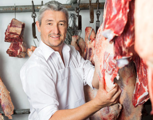 Butcher Holding Red Meat In Slaughterhouse