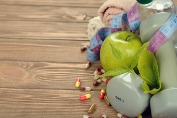 Dumbbells, apple and measuring tape