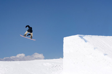 Snowboarder jumps in Snow Park