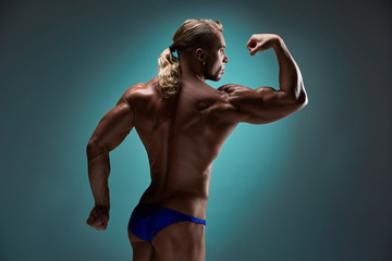 Obraz premium Attractive male body builder on blue background