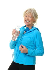 Sportliche Seniorin mit Wasserflasche und Kopfhörer