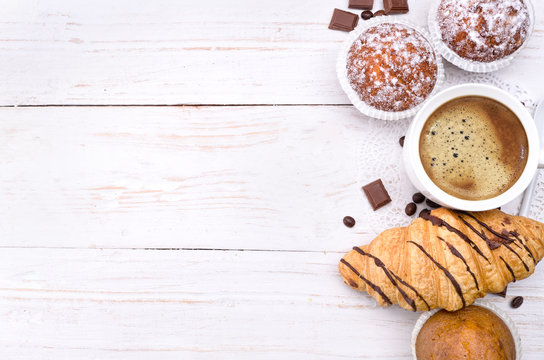 Coffee cup with a croissant and cake . Background.