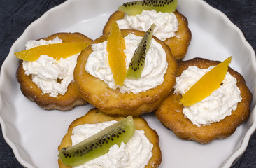 Cupcakes with whipped cream, orange and kiwi