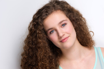 Cute teenage girl with curly hair smiling