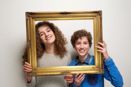 Happy boy and girl holding picture frame