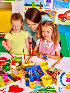 Children with teacher painting.