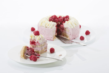 Himbeer-Sahnetorte auf Tortenplatte, Stück Torte auf Teller