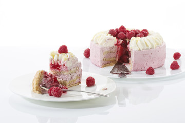 Himbeer-Sahnetorte auf Tortenplatte, Stück Torte auf Teller