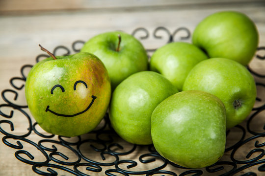 fruit. fresh green apples in plate on wooden background.