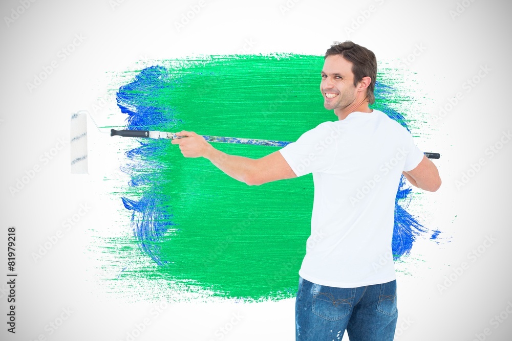 Aufkleber Composite image of happy man using paint roller